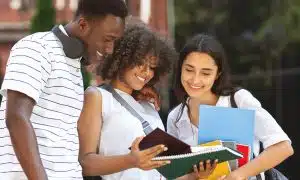 University students checking something in a notebook.