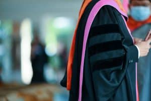 a person wearing a phd graduation gown