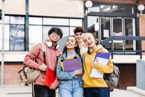 Group of students smiling next to a building.