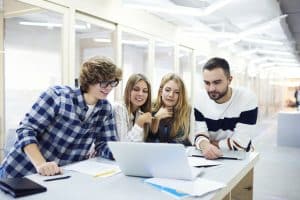 View of Video game design students talking in front of a computer.