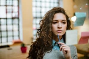 a female student thinking of something while looking on the paper