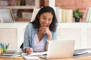 A woman smiling in front of a laptop