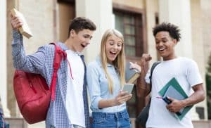 college students looking happy while looking at a phone screen