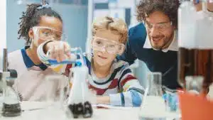 Little Boy Mixes Chemicals in Beakers.