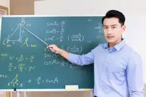 asian senior high school male teacher teach math online through webcam in classroom