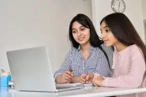 two female student looking at the laptop about Free Online Courses at Harvard