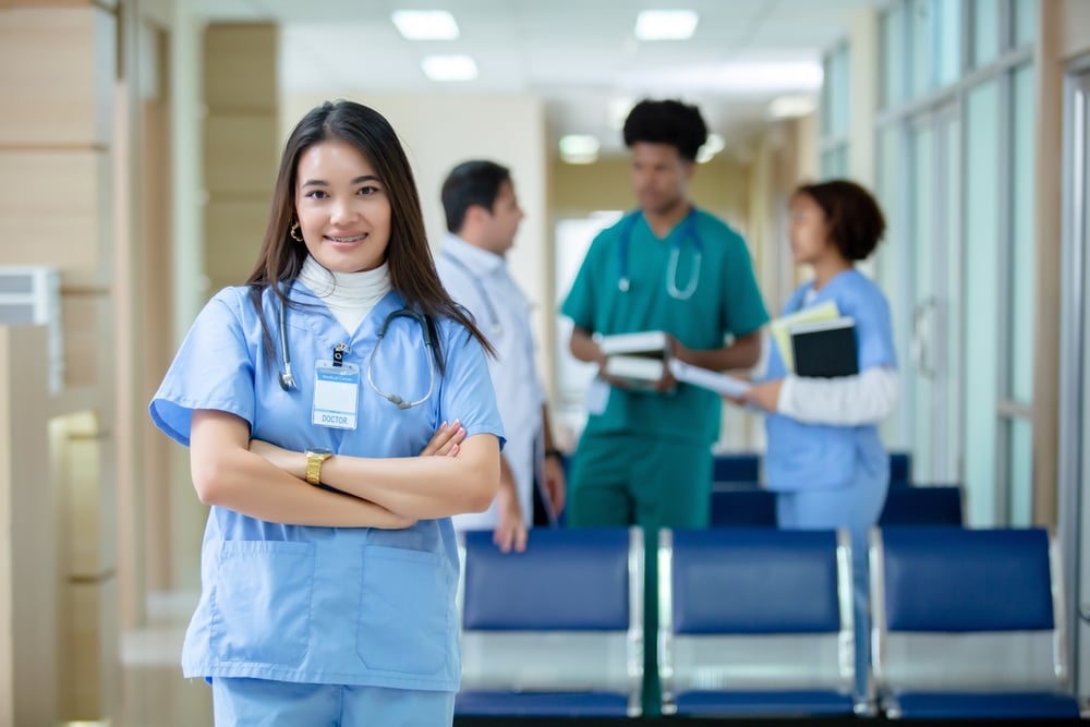 a medicine student wearing a blue scrub suit and looking at the camera
