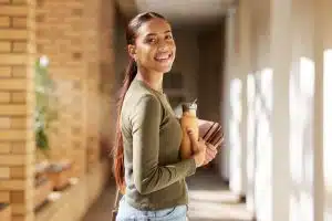 a female student standing in the middle of a hallway