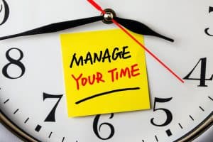 A post it note with the word manage your time.