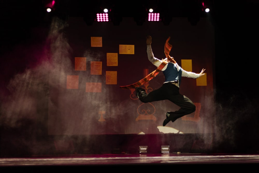 Actor dancer young man performs in the theater on stage in a retro dance musical show