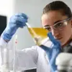 A serious student examines the contents of an ampoule while preparing for the International Chemistry Olympiad.