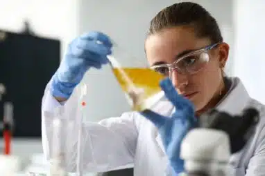 A serious student examines the contents of an ampoule while preparing for the International Chemistry Olympiad.