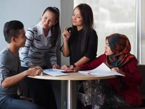 Group of students talking in a room.