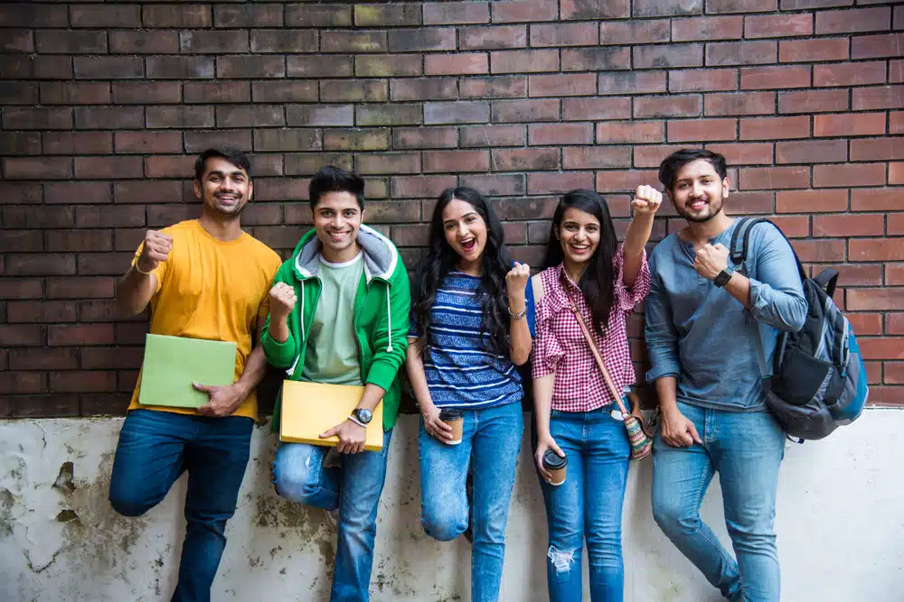 Cheerful Indian asian young group of college students or friends laughing together in campus