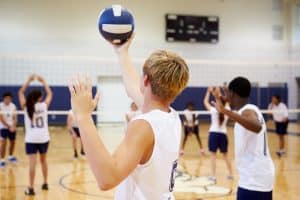 high school students playing volleyball inside the court