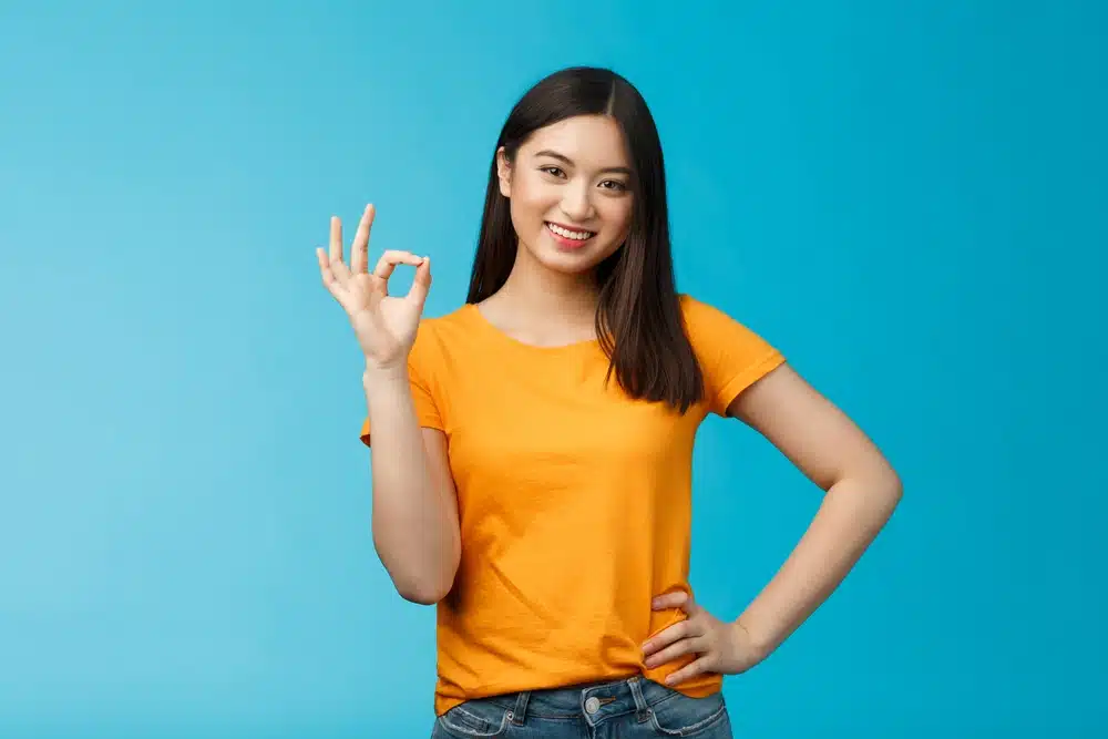 a sorority member standing making an okay sign with her fingers