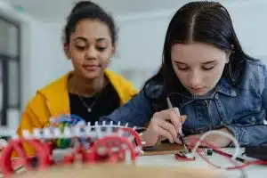 High school students building and programming electric toys and robots at robotics classroom