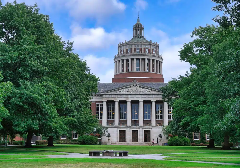 The campus of the University of Rochester, with the Rush Rhees Library at the end of a tree lined quadrangle
