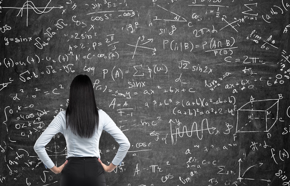 Rear view of a woman facing a blackboard.