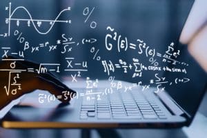 Hands using laptop with mathematical formulas.