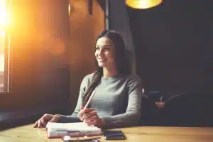 A woman writing in a table.