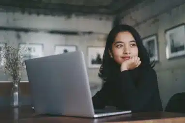 Asian beautiful woman thinking idea with laptop computer in coffee shop