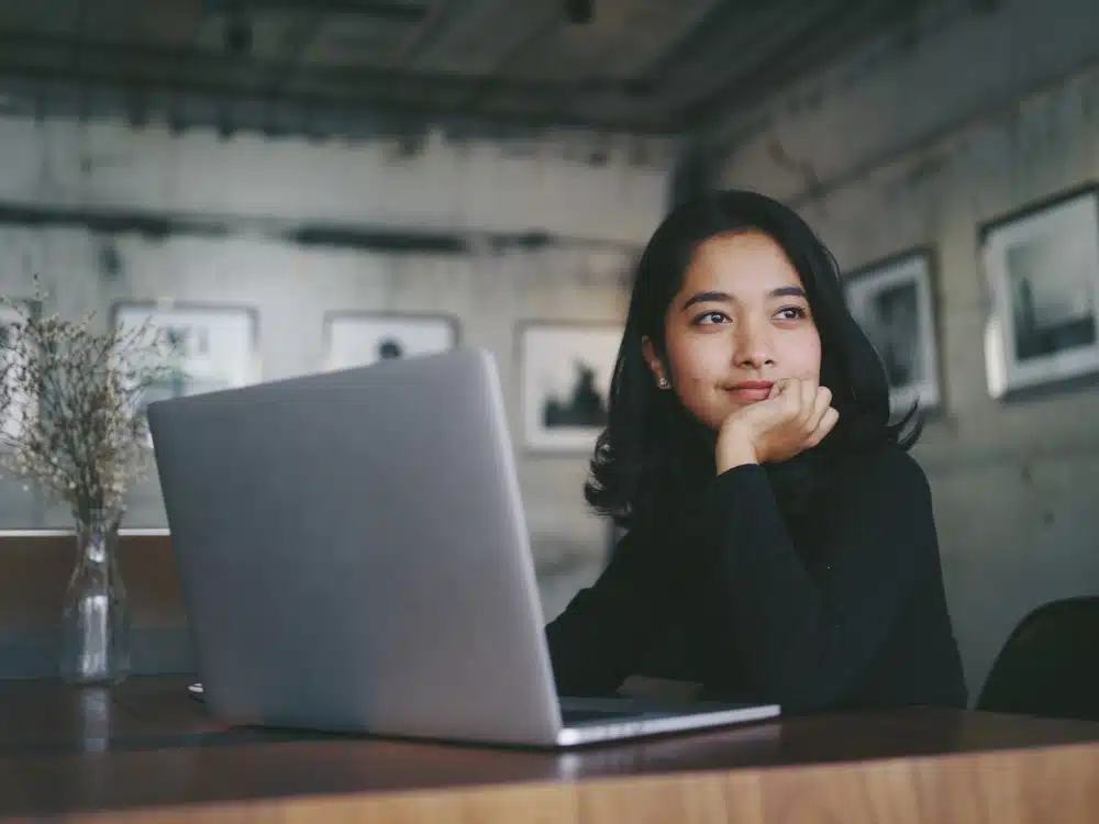 Asian beautiful woman thinking idea with laptop computer in coffee shop