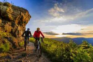 women and man riding on bikes at sunset