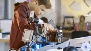 View of a boy working on a robot.
