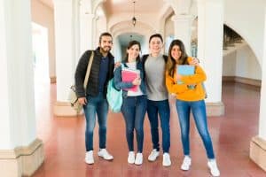 four students at the hallway smiling for the camera