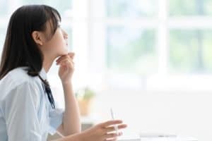 a student thinking while looking out at the window.