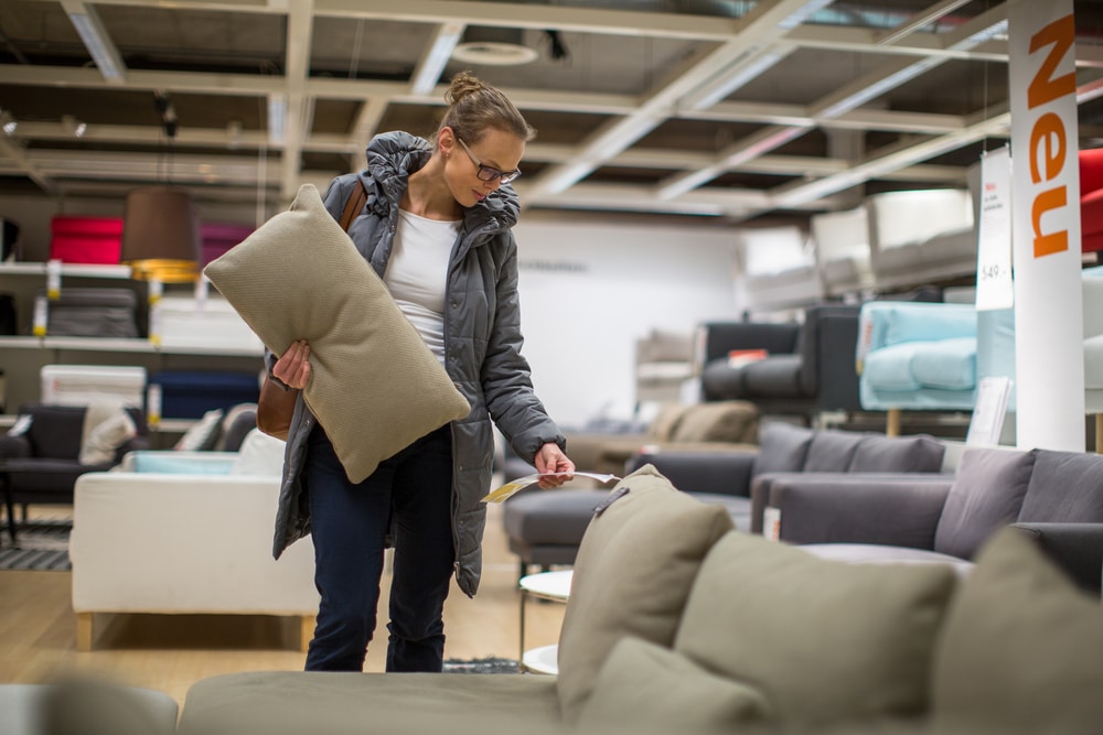 Pretty, young woman choosing the right furniture for her apartment