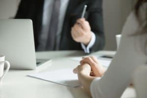 Close up of a woman being interviewed in an office.