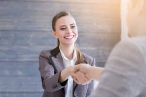 A woman shaking hands with her interviewer.