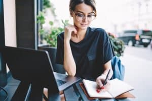 A woman writing an essay on a table.