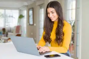 A woman typing in her table.