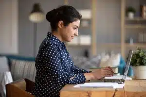 Young woman looking up something in her laptop.