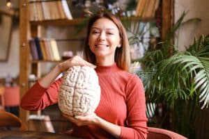 Female student holding a replica of a brain.