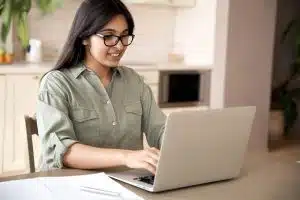 A female student typing on her laptop.