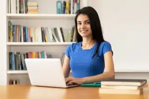 A woman typing in a library.