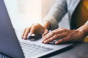 View of a man typing on his laptop.