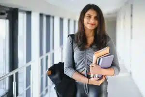 Pretty student walking in the hallway of a building.