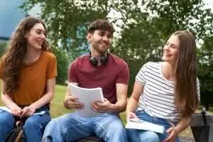 Three caucasian students talking to each other.