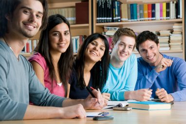 Group of students smiling at the camera, while deciding over the best ROI colleges