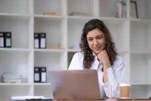 lady in white shirt facing her laptop