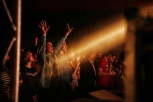 Young adults cheering out at a concert