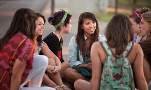 Female students talking outdoors on the sidewalk