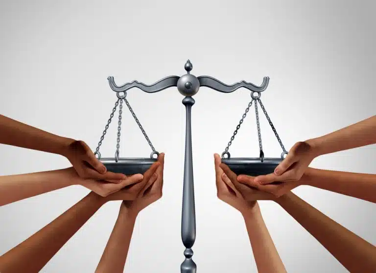 The scales of justice with hands supporting the balance