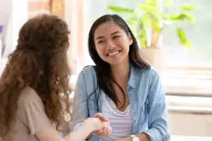 Young diverse friendly girls handshaking