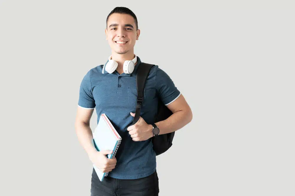 male college student with a backpack and headphones ready for school